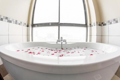 内罗毕里约酒店的窗户前的白色浴缸,上面有玫瑰花