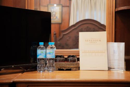 琅勃拉邦Villa Senesouk Luang Prabang的书桌上放两瓶水