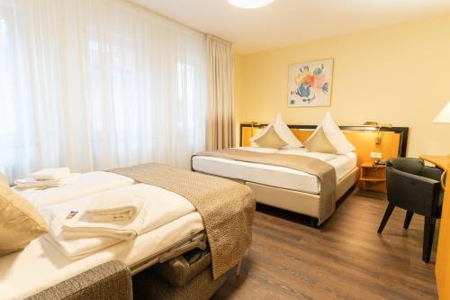 博登斯边的拉多夫采尔斯塔德花园酒店的酒店客房,配有两张床和椅子