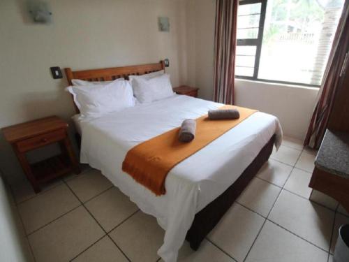 乌旺戈海滩Pebble Beach的一间卧室配有一张床,上面有两条毛巾