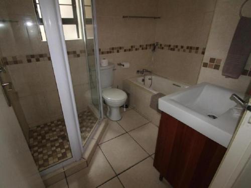 乌旺戈海滩Pebble Beach的浴室配有卫生间、淋浴和盥洗盆。