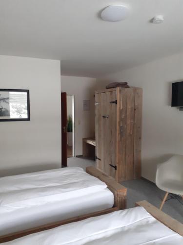梅德巴赫Pension Orketal的一间卧室设有两张床和木制橱柜