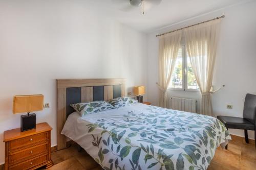 弗拉门卡海滩5 bedroom Villa private pool的卧室配有床、椅子和窗户。