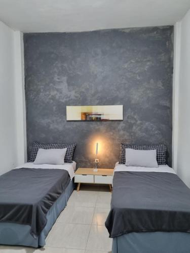 梭罗Choko Guest House的一间卧室配有两张床和一张带台灯的桌子