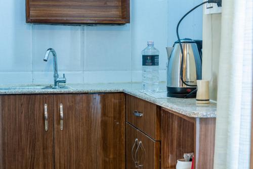 加德满都Kuna Resort的厨房柜台配有水槽和咖啡壶