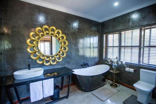 察嫩The Bohemian Guesthouse的带浴缸、水槽和镜子的浴室