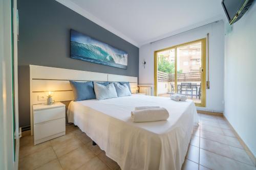 皮内达德马尔HomeHolidaysRentals Liberty - Costa Barcelona的卧室设有一张白色大床和一扇窗户。
