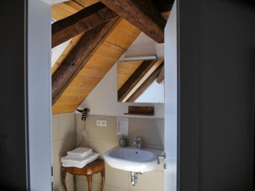 塞勒姆Pension & Café Schlupfwinkel的一间带水槽和木制天花板的浴室