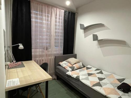 索斯诺维茨Apartament Gospodarcza的小房间设有一张床和一张桌子