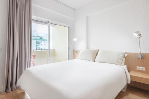 卡斯卡伊斯Equador Superior Suites by Olala Homes的白色的卧室设有一张大床和一个窗户