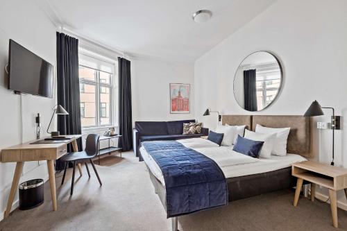 哥本哈根赫本伦贝斯特韦斯特酒店的一间卧室配有一张床、一张书桌和一面镜子