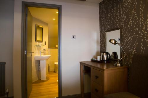 康威George & Dragon, Conwy的一间带水槽的浴室和一张带台灯的桌子