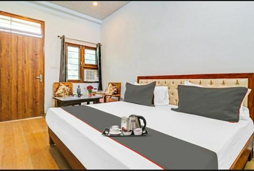 德拉敦Hotel StudioZ Sahastradhara的一间卧室配有一张大床,上面有托盘