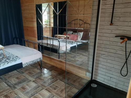 Domek dla par agroturystyka siedlisko的一间设有床铺和玻璃墙的房间
