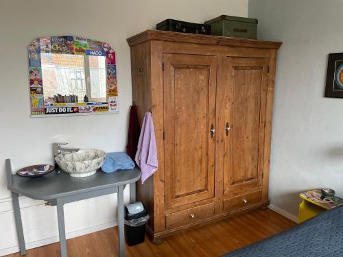阿尔克马尔Comfortable Room的卧室内的木柜,配有桌子