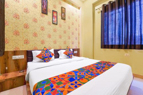 乌代浦FabHotel Lotus的一间卧室配有一张大床和色彩缤纷的毯子