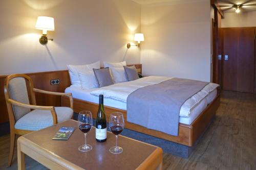 阿尔岑瑙·因·尤特弗兰恩Käfernberg - Weinhotel的酒店客房带一张床和两杯葡萄酒