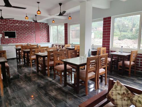 德拉敦Hotel StudioZ Sahastradhara的一间带桌椅的餐厅以及砖墙