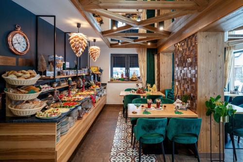 扎科帕内Serce Tatr Residence Zakopane - blisko Krupówek的餐厅设有木制天花板、桌子和绿色椅子