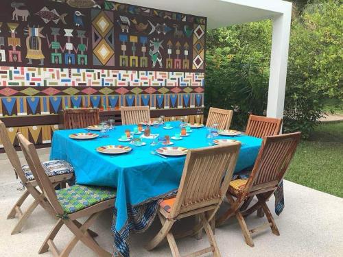 斯基灵角Villa CITRONS VERTS dans un parc arboré vue mer的一张桌子、椅子和蓝桌布