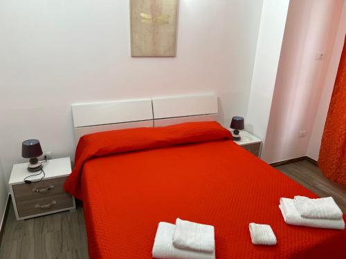 科森扎B&B l’antico rudere 2的一间卧室配有橙色床和两条白色毛巾