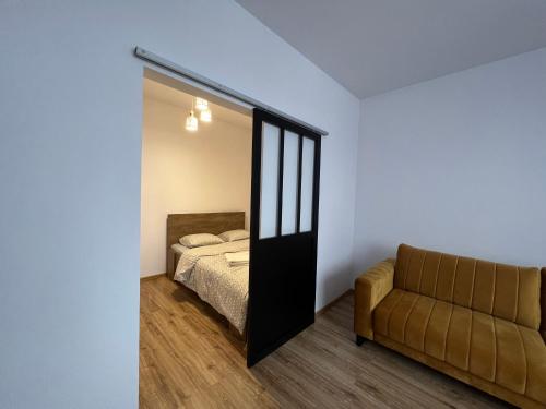 帕比亚尼采Nowe mieszkanie, fajna kamienica的一间卧室配有一张床、镜子和一张沙发