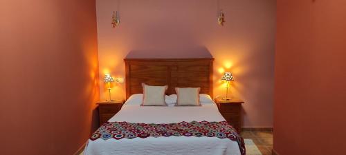 桑托托梅德尔普埃尔托Apartamentos Turísticos La Casa de Dafne的一间卧室配有一张大床和两盏灯