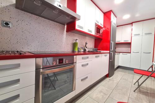 萨拉戈萨Dos Torres Conde Aranda - Céntrico con estacionamiento Incluido的一间厨房,配有白色的橱柜和红色的点缀