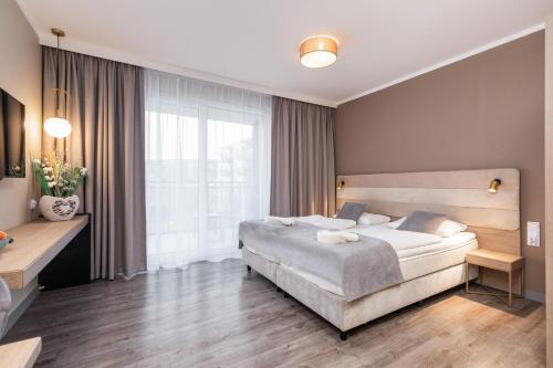 米兹多洛杰Miedzyzdroje SEASIDE Apartments Bel Mare by Renters的一间卧室设有一张床和一个大窗户