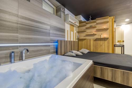 TrebnjePrivate Wellness Apartment的一间带浴缸和床的卧室