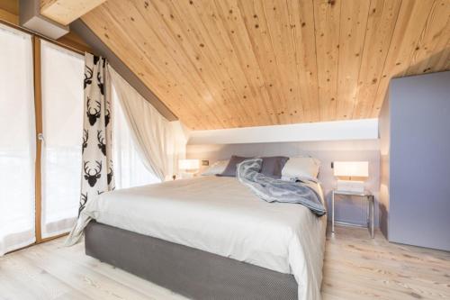 福尔加里亚Folgaria Top Rent的一间卧室设有一张床和木制天花板