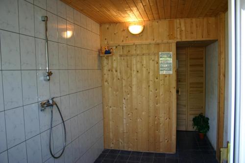 奥茨塞巴德·迪尔哈根Ferienwohnung Zaepernick Erdgeschoss的带淋浴的浴室和木墙