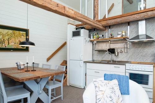胡迪克斯瓦尔Seaside Cottage House nr 1, Saltvik Hudiksvall的一间带桌子的厨房和一间带冰箱的厨房