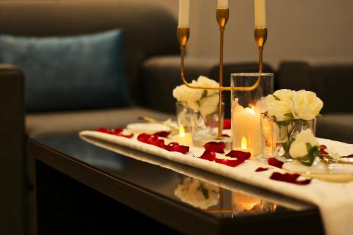 艾卜哈فندق فصل الصيف امان - المنسك的一张桌子上放着蜡烛和鲜花