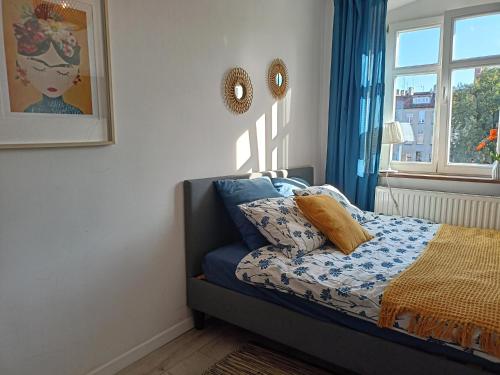 莱格尼察Lemuria Pokój z łazienką Szkolna的一间卧室配有一张带蓝色窗帘的床和一扇窗户