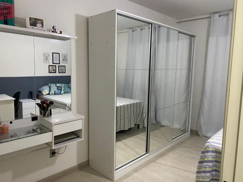 迪亚曼蒂纳Apartamento Diamante的卧室配有玻璃衣柜和床