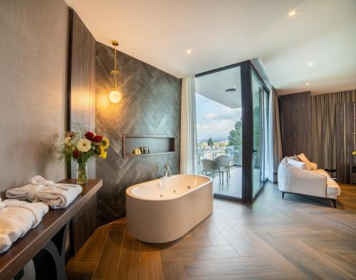 凯里尼亚Hotel Pia Bella的带浴缸的浴室和卧室