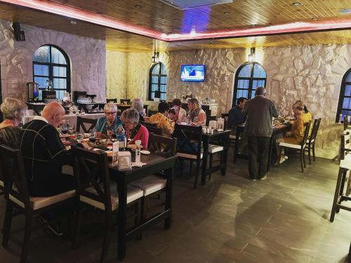 马达巴Mount Nebo Hotel & Restaurant Madaba City Center的一群坐在餐厅桌子上的人