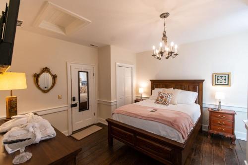 刘易斯堡Thomas Rose Inn的一间卧室配有一张床、一张桌子和一个吊灯。