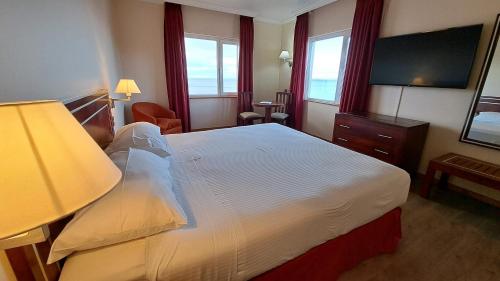 蓬塔阿雷纳斯迭戈阿尔马格罗蓬塔阿雷纳斯酒店的酒店客房,配有床和电视