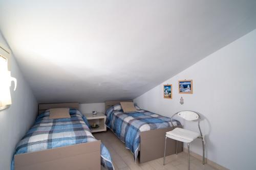 贾迪尼-纳克索斯Casa Vacanza Giugiò的一间卧室配有两张床和一张桌子
