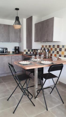 安格雷T2 NEUF ANGLET CENTRE - BIARRITZ的厨房配有木桌和两把椅子