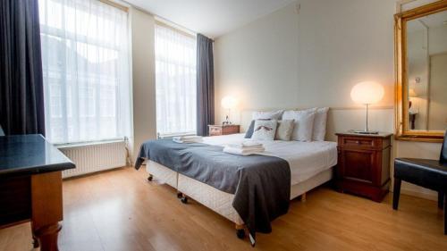 博尔斯瓦德Hotel de Wijnberg的一间卧室配有一张大床和镜子