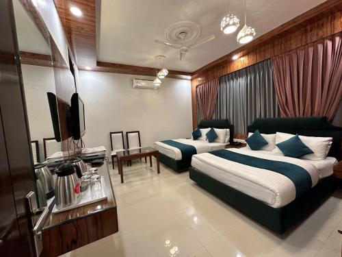 新德里Hotel Baba Deluxe -By RCG Hotels的酒店客房设有两张床和一台平面电视。