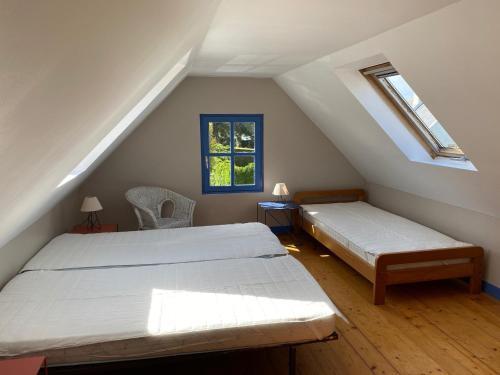 洛克马里亚Maison Locmaria, 2 pièces, 4 personnes - FR-1-418-163的阁楼卧室设有两张床和窗户。