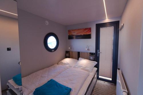 温德托尔夫Hausboot Fjord Lacerta mit Dachterrasse in Wendtorf的一间小卧室,配有床和窗户