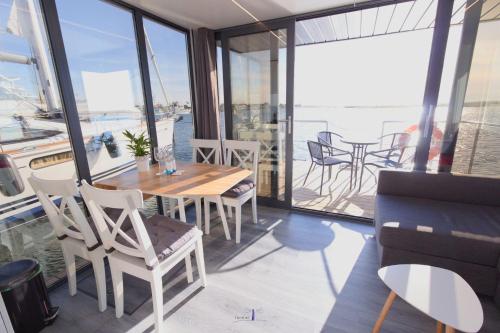 温德托尔夫Hausboot Fjord Lacerta mit Dachterrasse in Wendtorf的一间带桌椅和窗户的用餐室