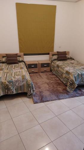 丹吉尔ESPACIOSO的客房设有两张床,铺有瓷砖地板。