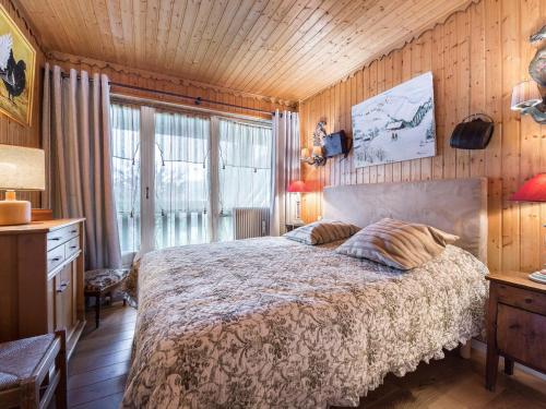 梅杰夫Appartement Megève, 4 pièces, 8 personnes - FR-1-453-14的卧室配有一张床铺,位于带木墙的房间内