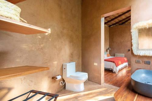 图卢姆OJO DE AGUA. Design+pool. Vive la auténtica selva!的一间带卫生间、水槽和床的浴室